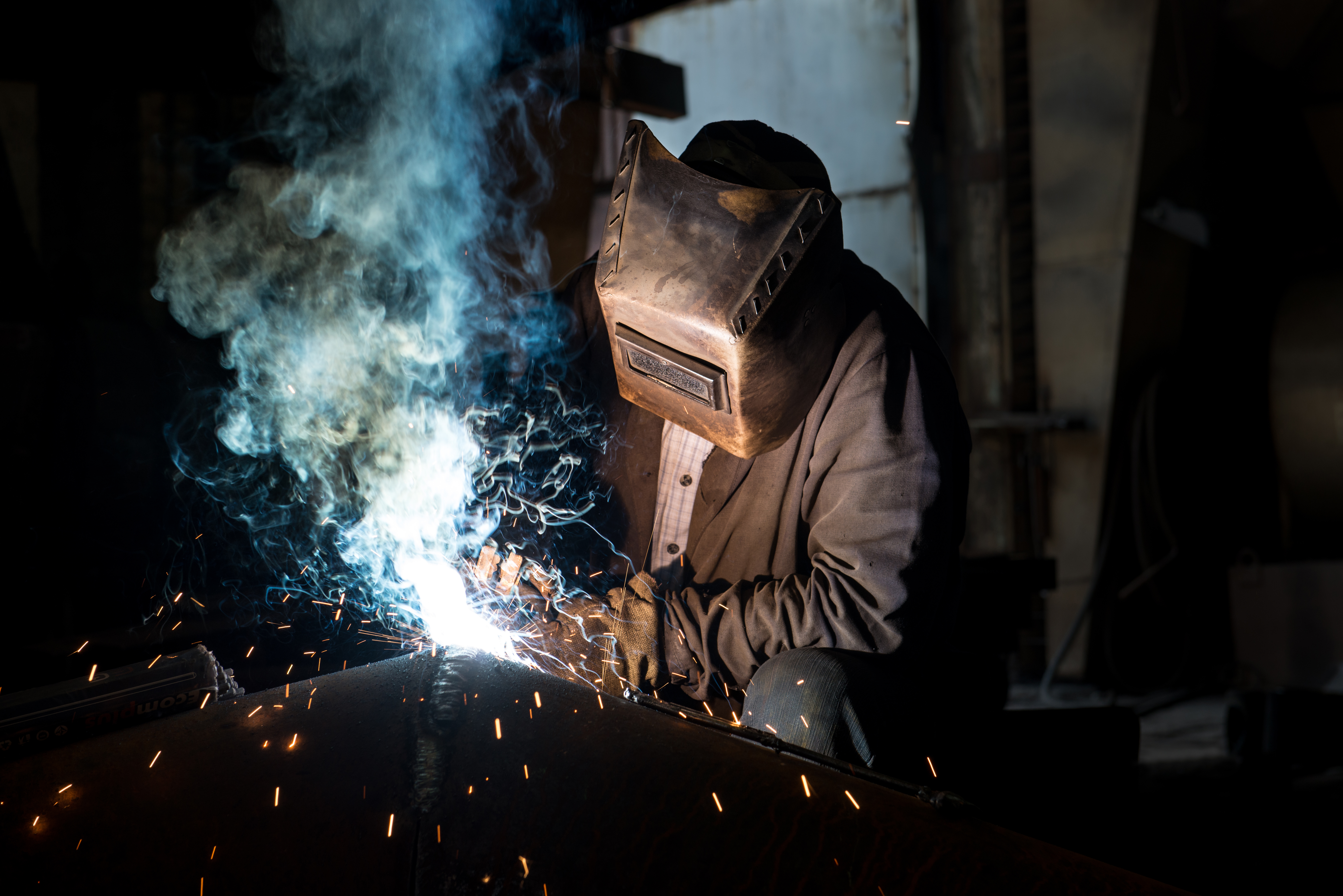 Arbeiter in industrieller Umgebung, geschützt durch molekulare Aktivkohlefiltration – ISO 10121 Gasphasen-Luftreinigung für die Arbeitsplatzluftqualität